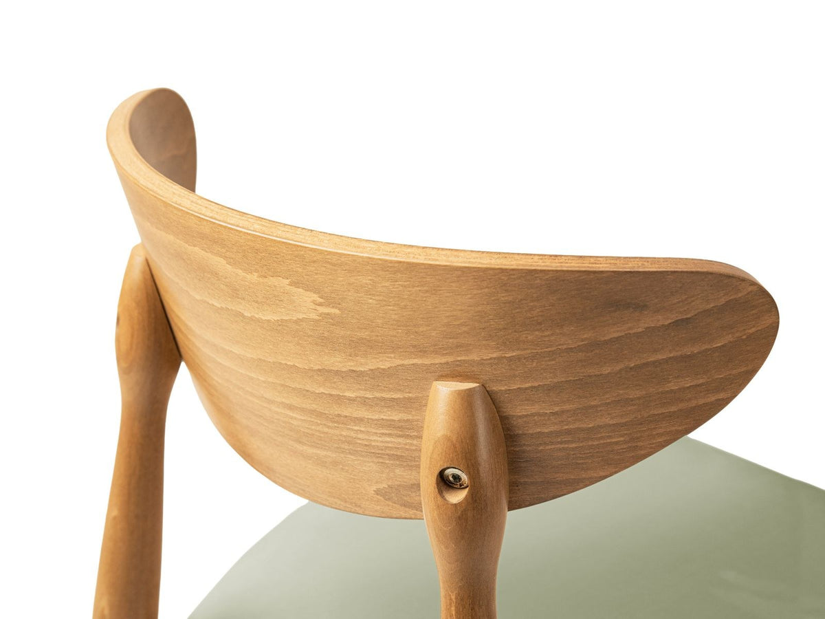 Zwei Leon Stühle mit Samtbezug in Almond Beige, Buchenholz-Beinen und gepolsterter Rückenlehne, Frontalansicht auf hellem Hintergrund.