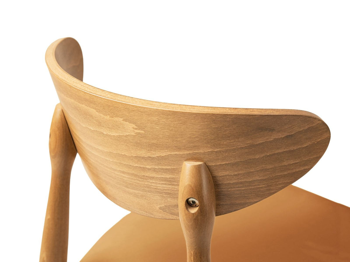 Zwei Leon Stühle mit Samtbezug in Almond Beige, Buchenholz-Beinen und gepolsterter Rückenlehne, Frontalansicht auf hellem Hintergrund.