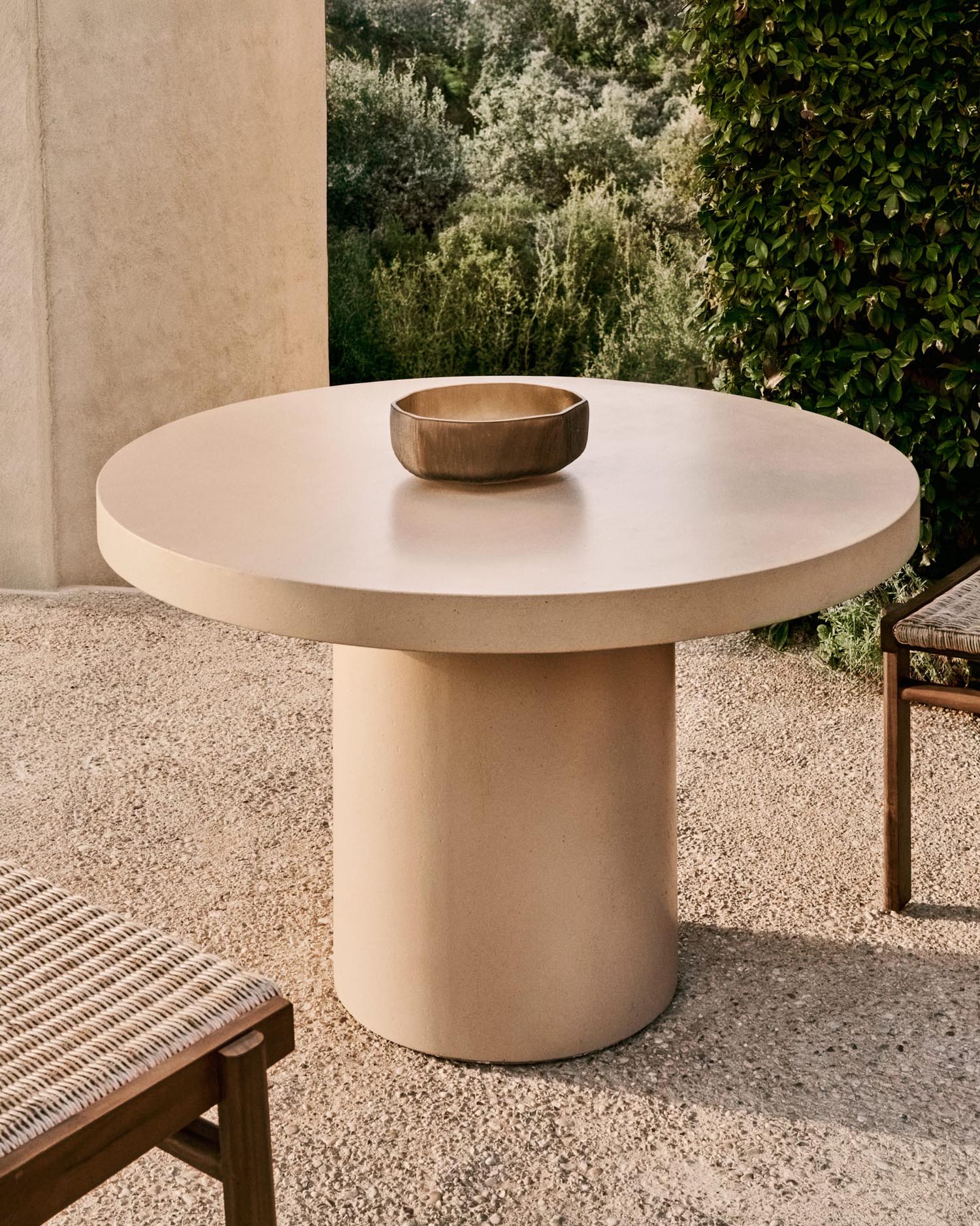 Eleganter runder Tisch aus beigem Zement, Ø 120 cm, perfekt für moderne Wohnräume und Gärten, von Kave Home.