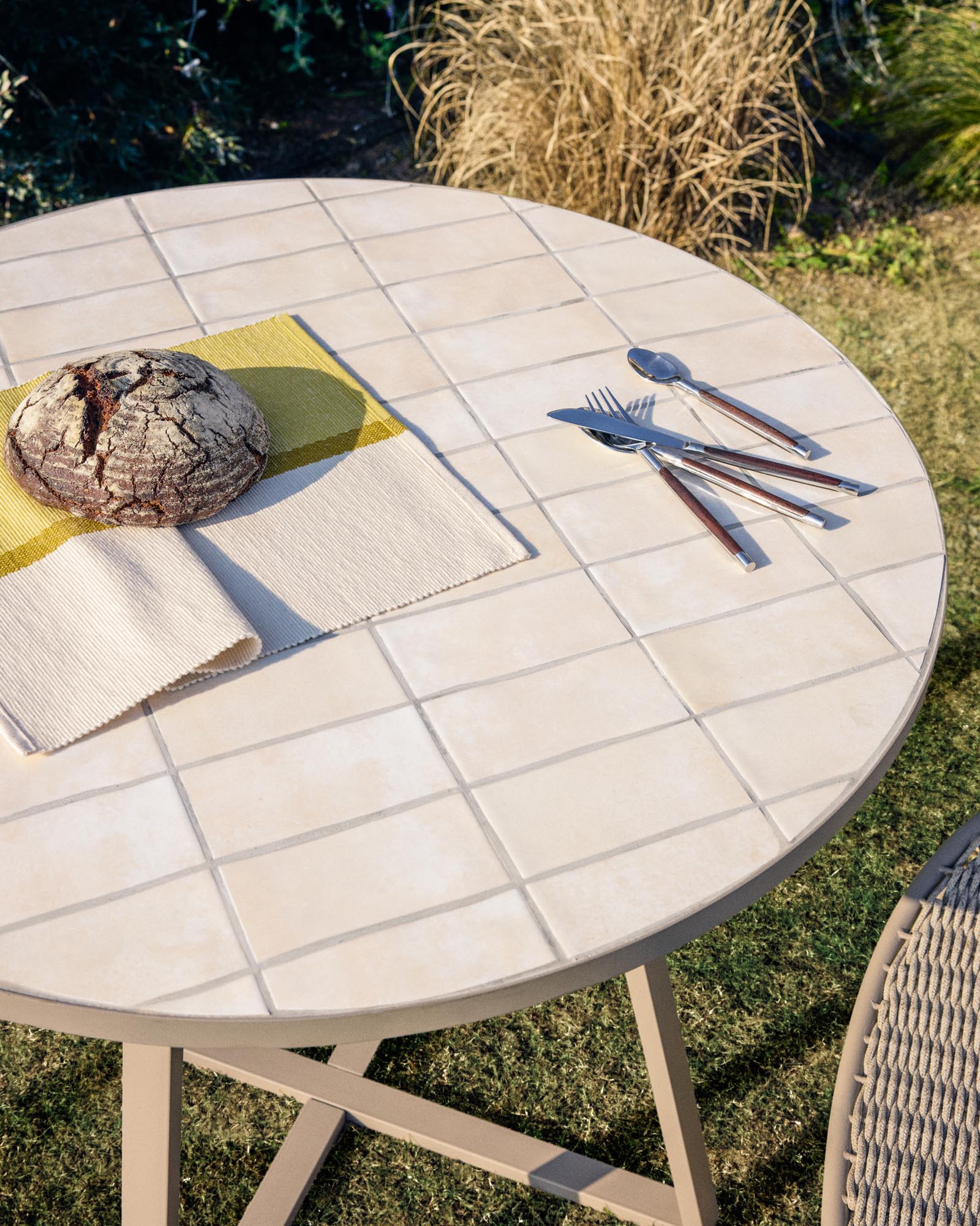 Eleganter runder Gartentisch Tella mit robustem verzinktem Stahl und stilvollen beigen Fliesen, Ø 120 cm, ideal für entspannte Stunden im Freien.