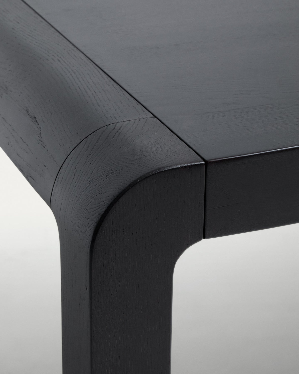 Schwarzer Ausziehtisch aus massivem Eichenholz mit ebonisiertem Finish, rechteckige Tischplatte und Beine mit Gummipolstern und Rollen.