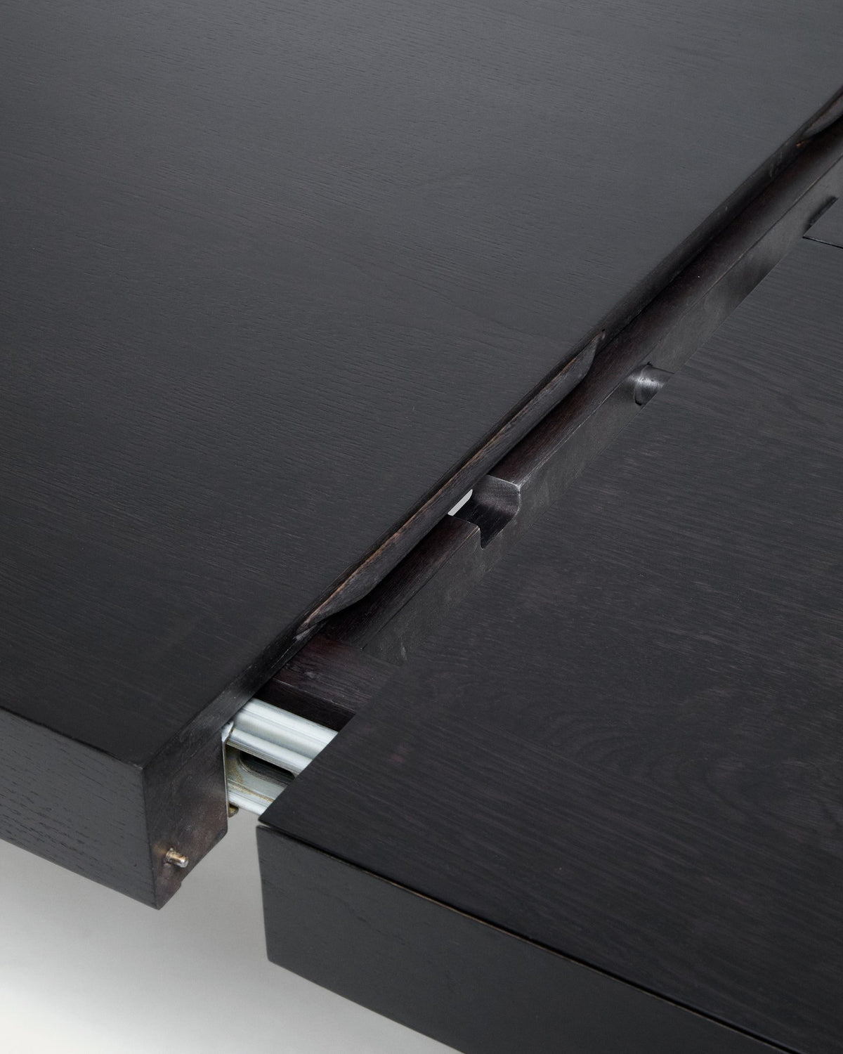 Schwarzer Ausziehtisch aus massivem Eichenholz mit ebonisiertem Finish, rechteckige Tischplatte, Beine mit Rollen auf einer Seite.