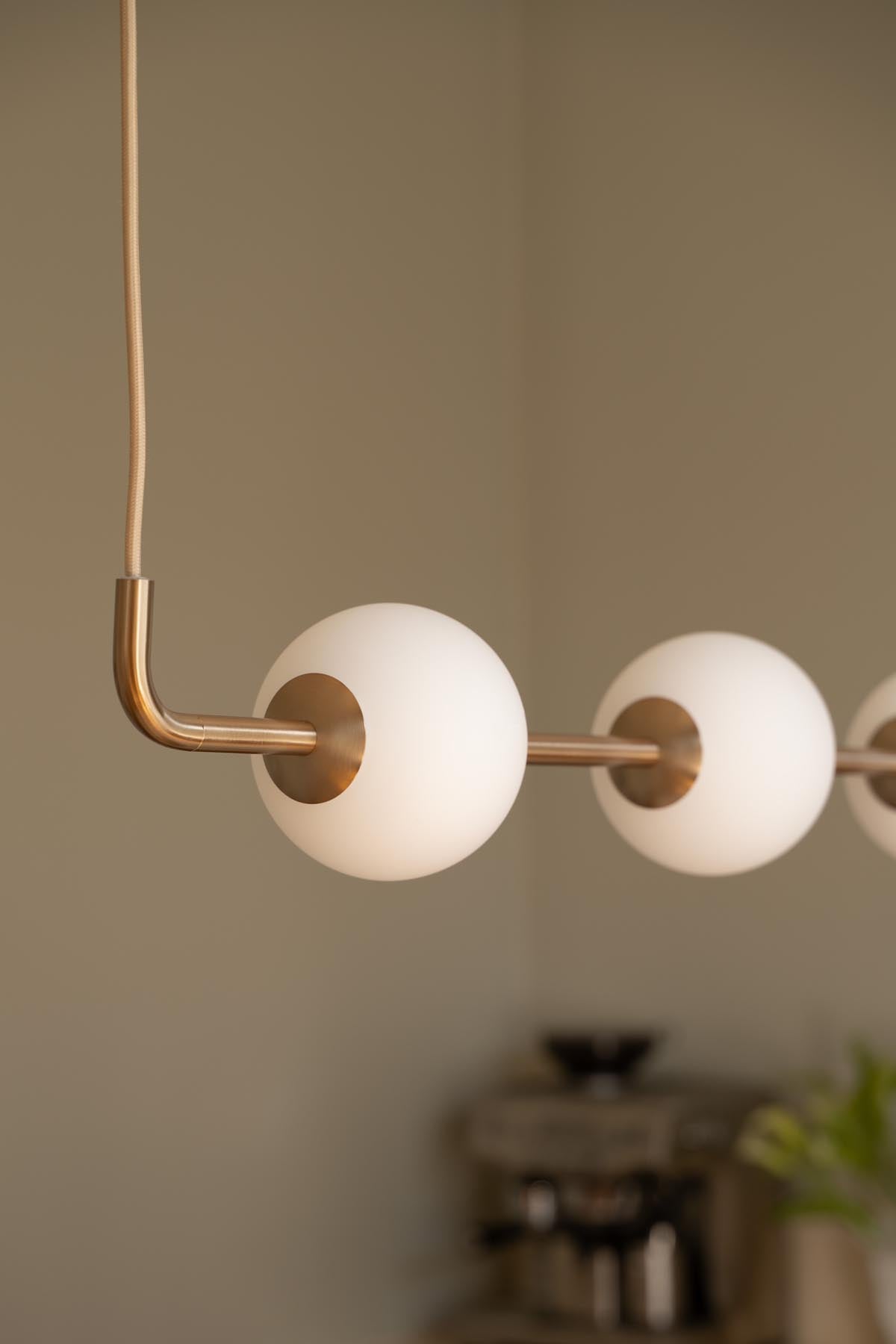 Elegante Audrey Linear Pendellampe von Umage in hochwertigem Messing, ideal für stimmungsvolle Lichtakzente in modernen Wohnräumen.