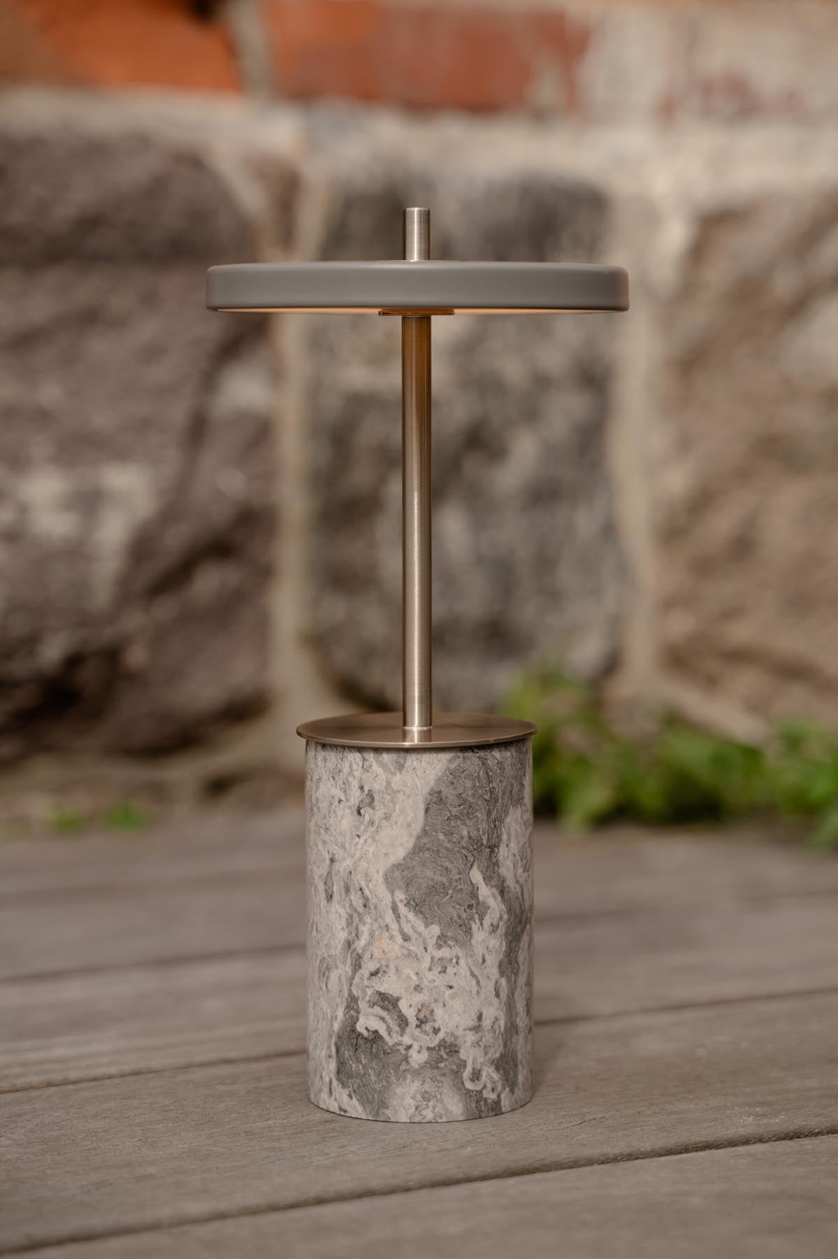 Moderne Asteria Move Mini Tischleuchte aus grauem Marmor und Stahl, perfekt für stimmungsvolle Beleuchtung und zeitgemäßes Design.