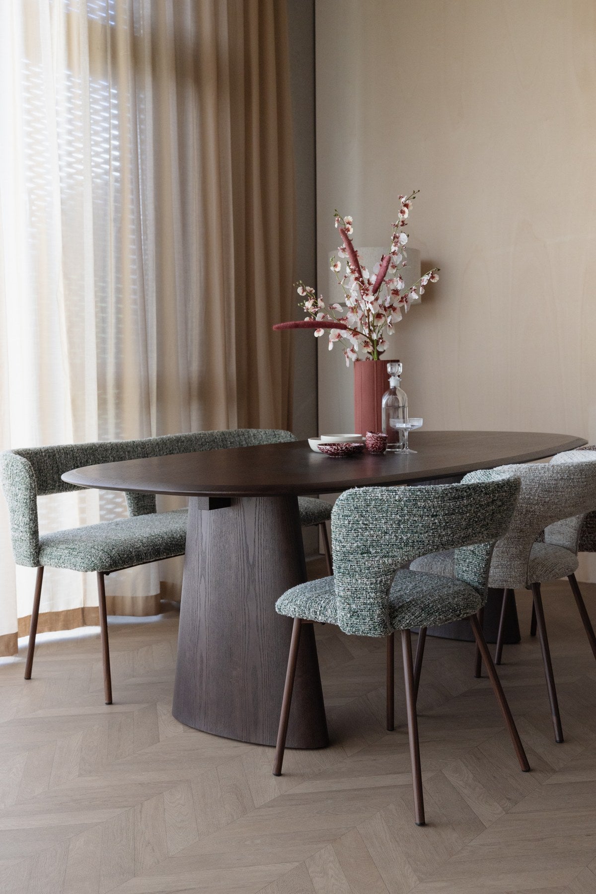 Esstisch Mandy von White Label Living mit ovaler Tischplatte aus Eschenfurnier, schwarzem Gestell und dunklem Walnussfarbton.
