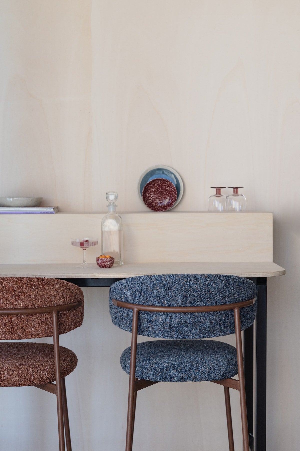 Blauer Barhocker Claes mit meliertem Polyester-Bezug, gepolsterter Sitzfläche und Metallgestell in Walnuss-Holzoptik-Finish.