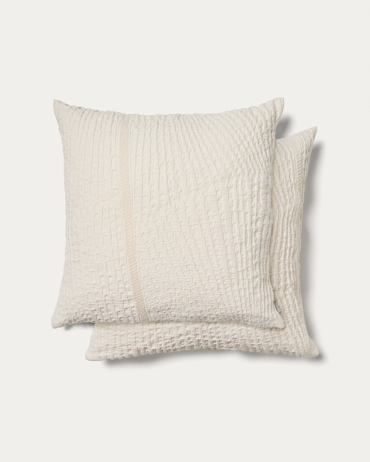 Zwei quadratische Kissenbezüge aus Baumwolle in Ecru mit reliefartigen Streifen, Grösse 50 x 50 cm, flach ausgebreitet.