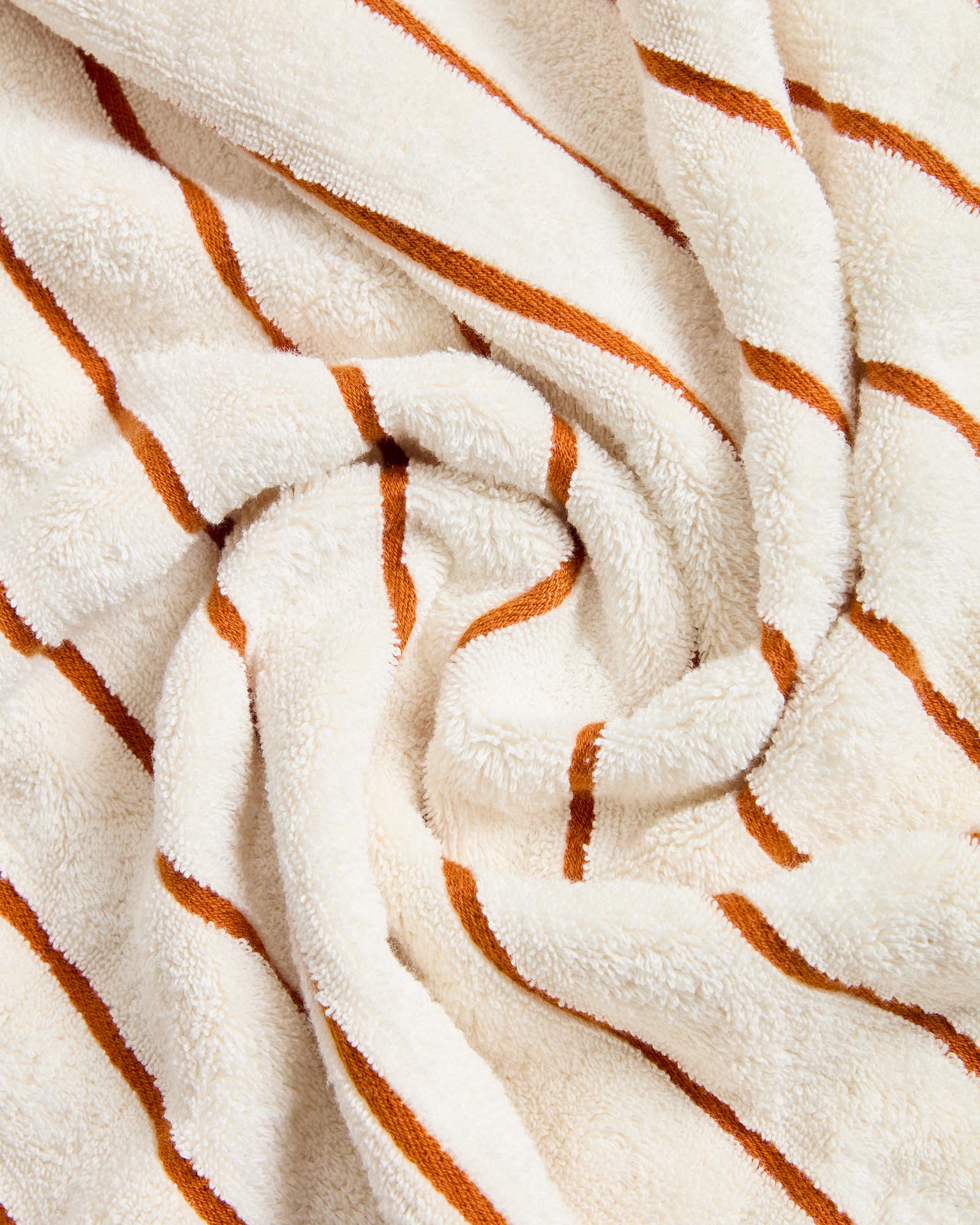 Elegantes Handtuch Dorane in 50 x 90 cm, gefertigt aus 100 % Baumwolle, mit stilvollen orangefarbenen Streifen, ideal für Bad und Wellness.