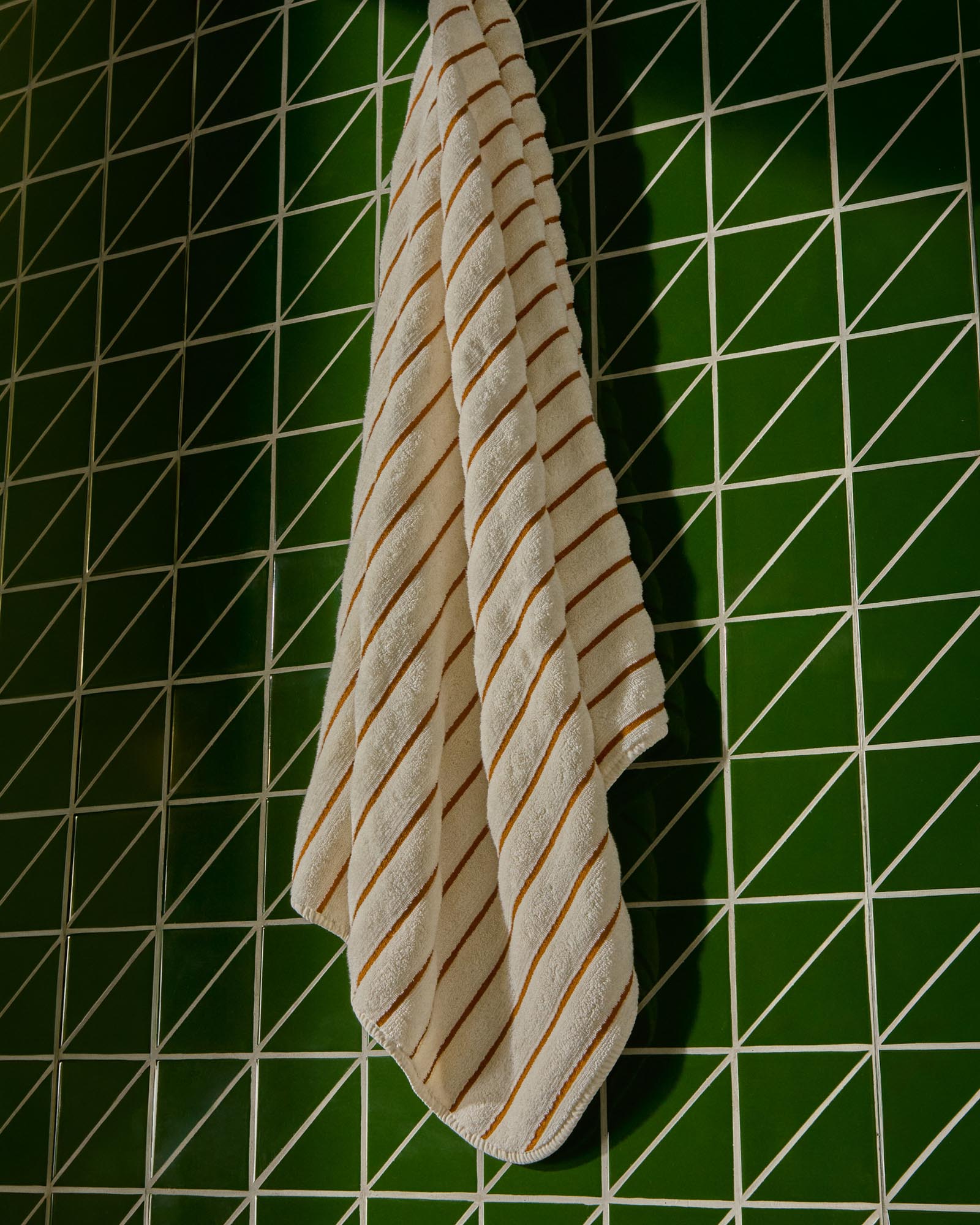 Hochwertiges Handtuch Dorane in 70 x 140 cm, aus 100 % Baumwolle, verziert mit modernen orangefarbenen Streifen, perfekt für jeden Badezimmerstil.
