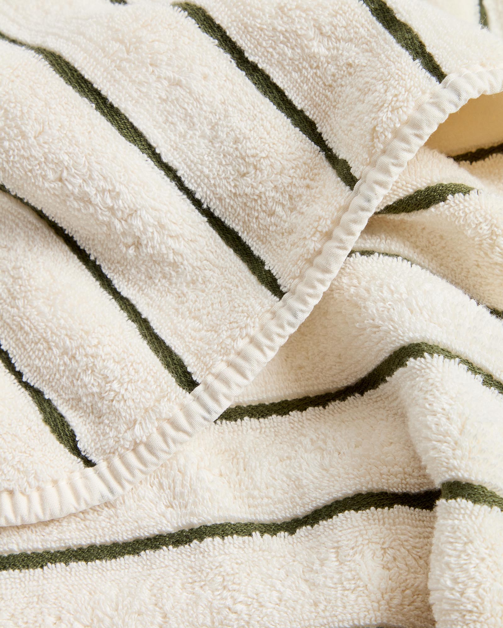 Elegantes Handtuch Dorane in sanften Grüntönen, gefertigt aus 100 % Baumwolle, ideal für stilvolle Badezimmer und den täglichen Gebrauch.