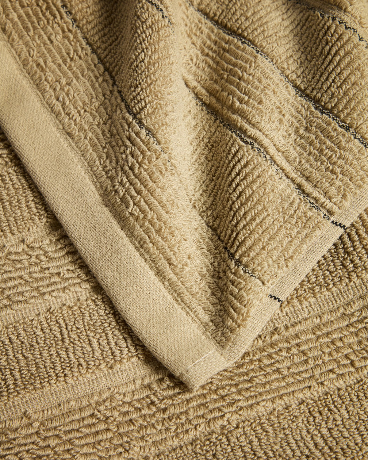 Grünes Handtuch aus Baumwolle mit Jacquard-Streifenmuster, gefaltet auf einer Fläche liegend, Grösse 50 x 90 cm.