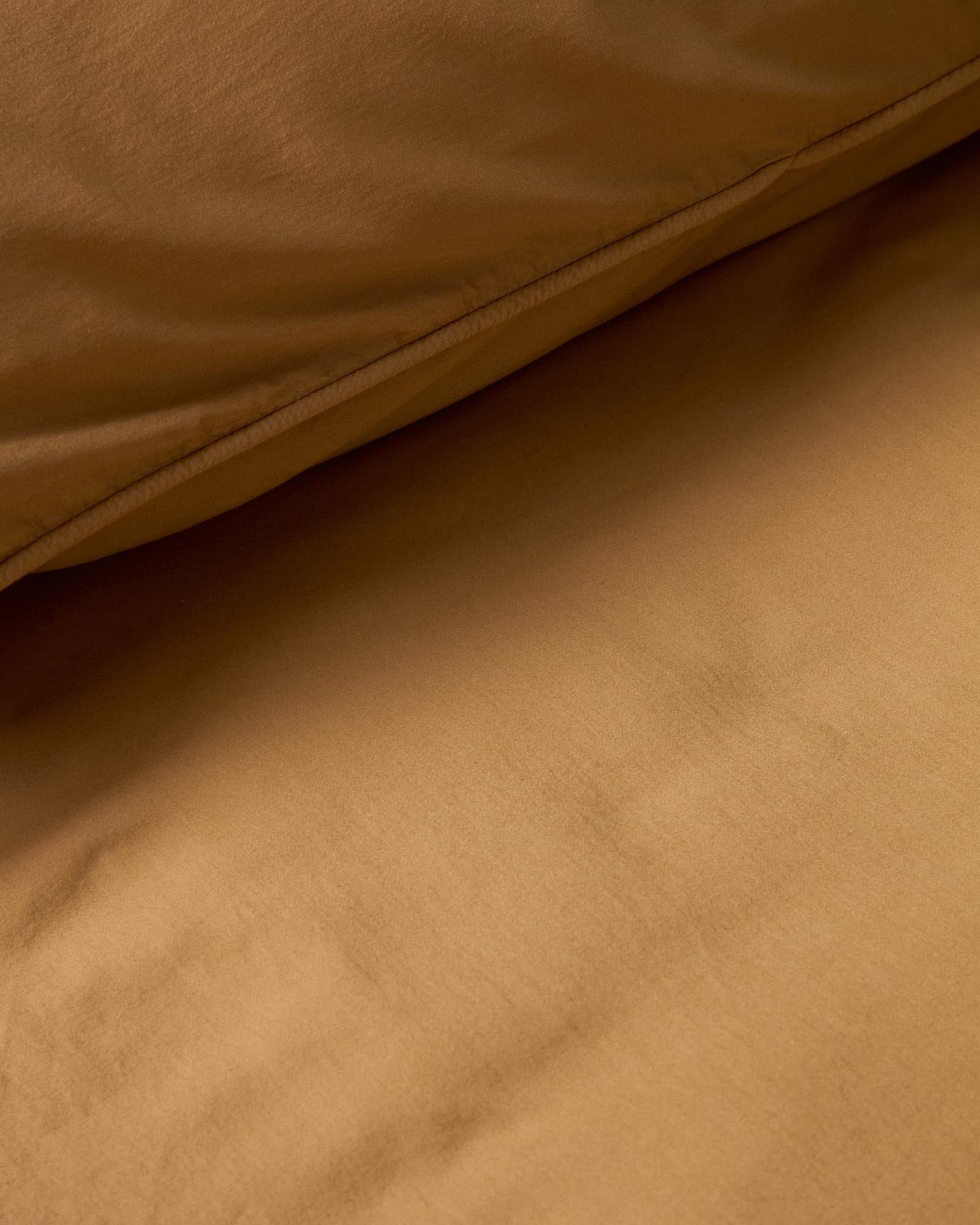 Eleganter Bettbezug Sirale in warmem Kupfer, gefertigt aus 100 % Baumwollsatin mit einem sanften Washed-Finish, ideal für 150/160-cm-Betten.