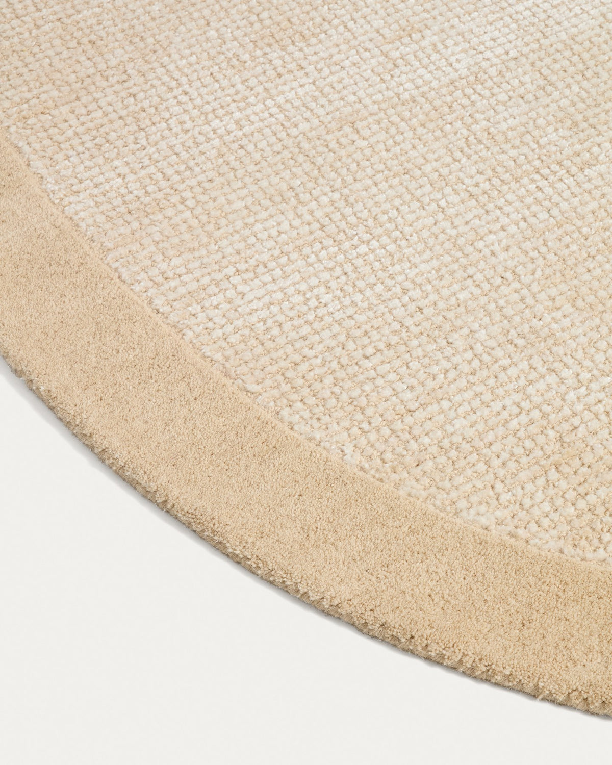 Beige Teppich Ivena von Kave Home mit Wollrahmen und Viskose-Innenseite, handgewebt mit sichtbaren Naturfaser-Unregelmässigkeiten.