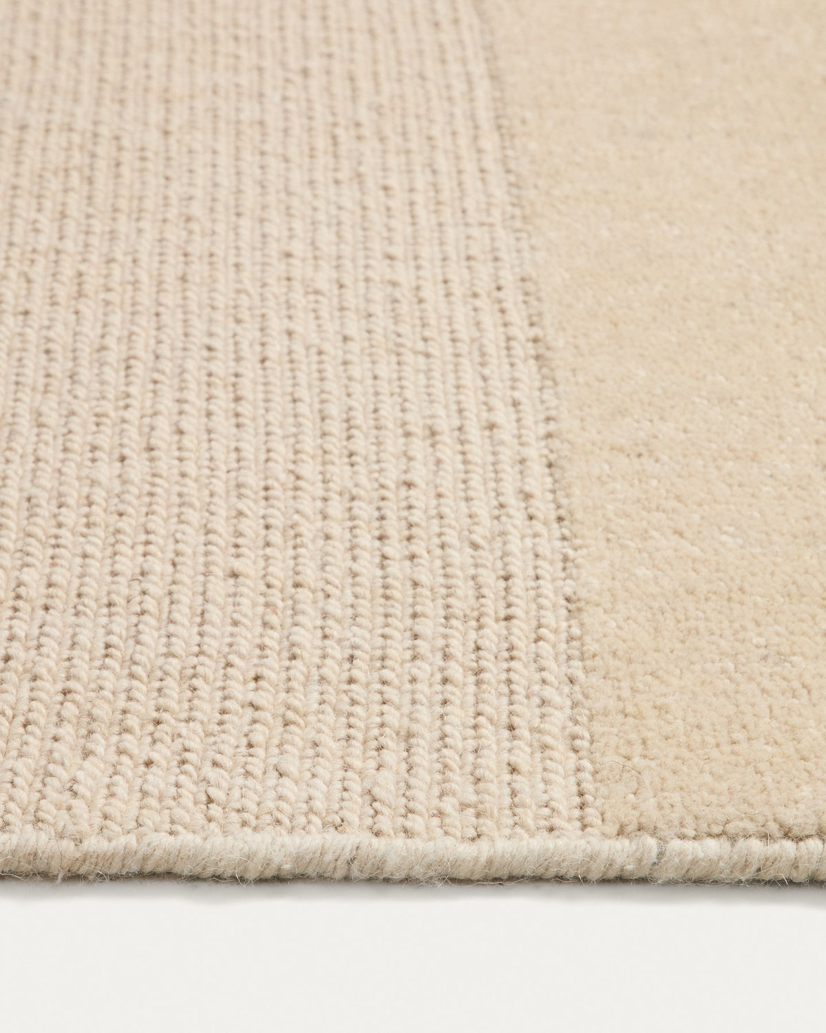 Beiger Wollteppich Esola von Kave Home aus 100% Wolle, handgewebt mit sichtbarer Struktur und leichten Unregelmässigkeiten.