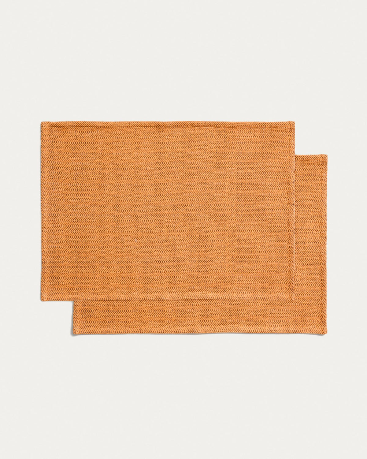 Zwei rechteckige Tischsets aus Baumwolle mit Jacquard-Muster in Senfgelb, Grösse 35 x 50 cm, auf einem Tisch platziert.
