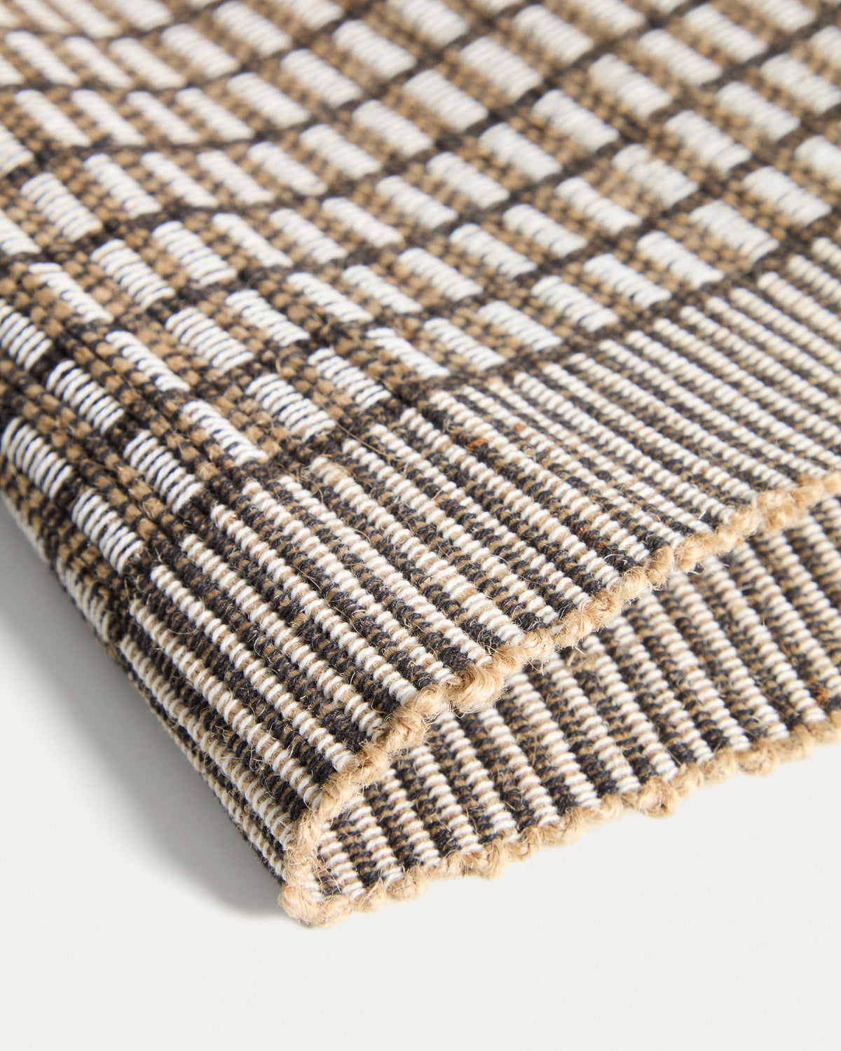 Zwei senfgelbe Tischsets aus Baumwolle und Jute mit strukturierter Webung, rechteckige Form, auf einer Tischplatte platziert.