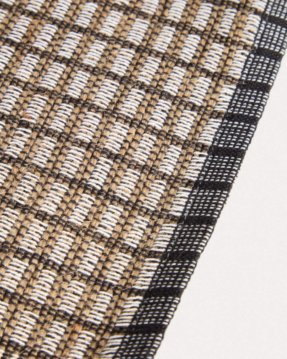 Zwei senfgelbe Tischsets aus Baumwolle und Jute mit strukturierter Webung, rechteckige Form, auf einer Tischplatte platziert.