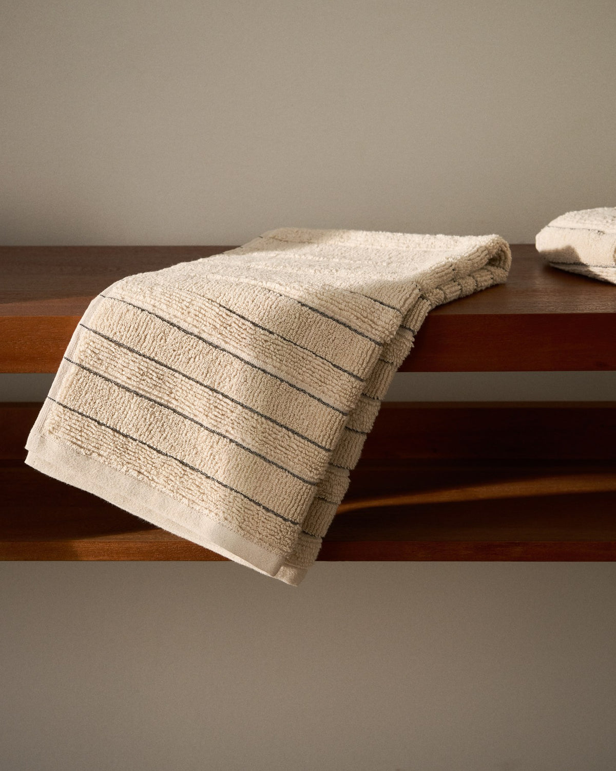 Beiges Handtuch aus 100 % Baumwolle mit Jacquard-Muster in Streifenoptik, rechteckige Form, Grösse 50 x 90 cm.