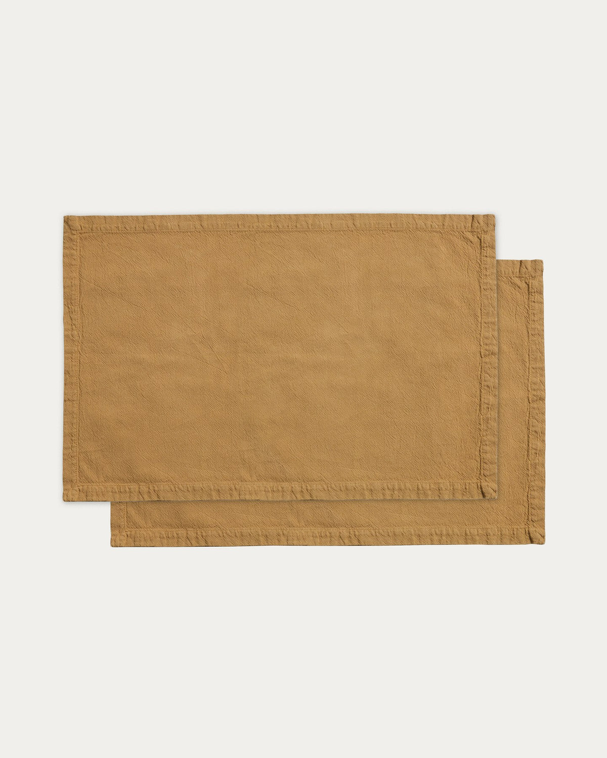 Zwei rechteckige Tischsets aus senfgelber Baumwolle mit Washed-Finish, gewebte Struktur, Grösse 35 x 50 cm, auf hellem Hintergrund.
