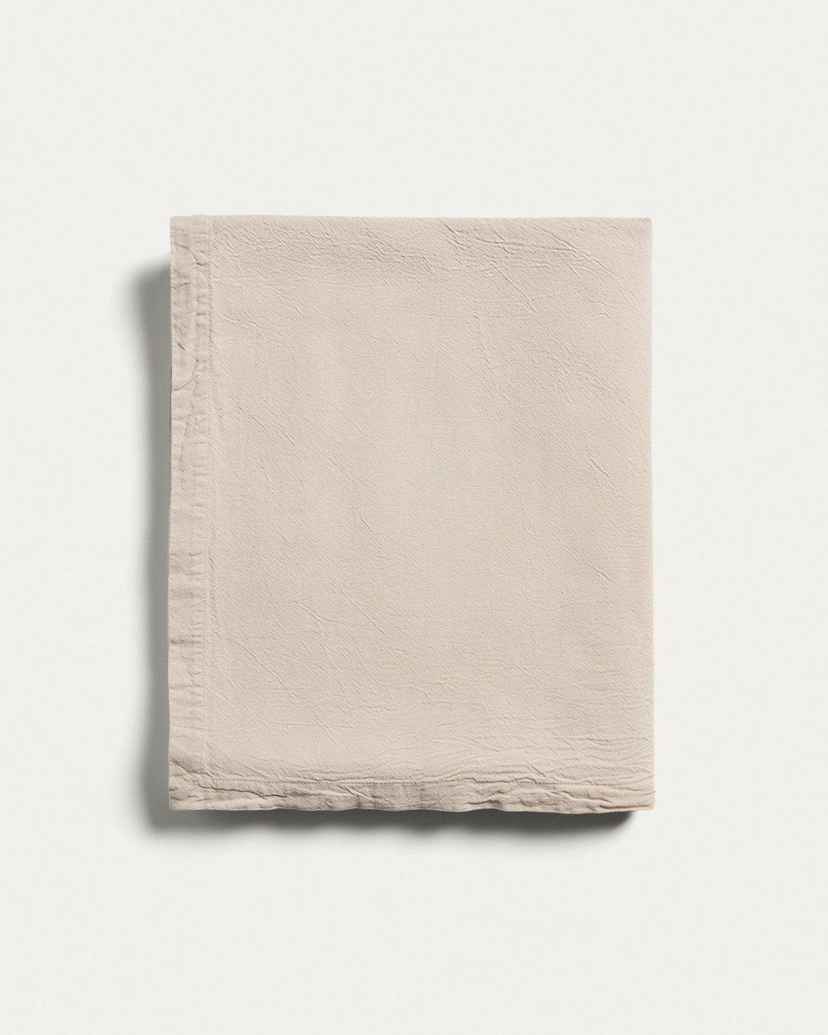 Steinfarbene Tischdecke Levara aus Baumwolle mit Washed-Finish, rechteckige Form, ausgebreitet auf einem Esstisch, Grösse 170 x 250 cm.