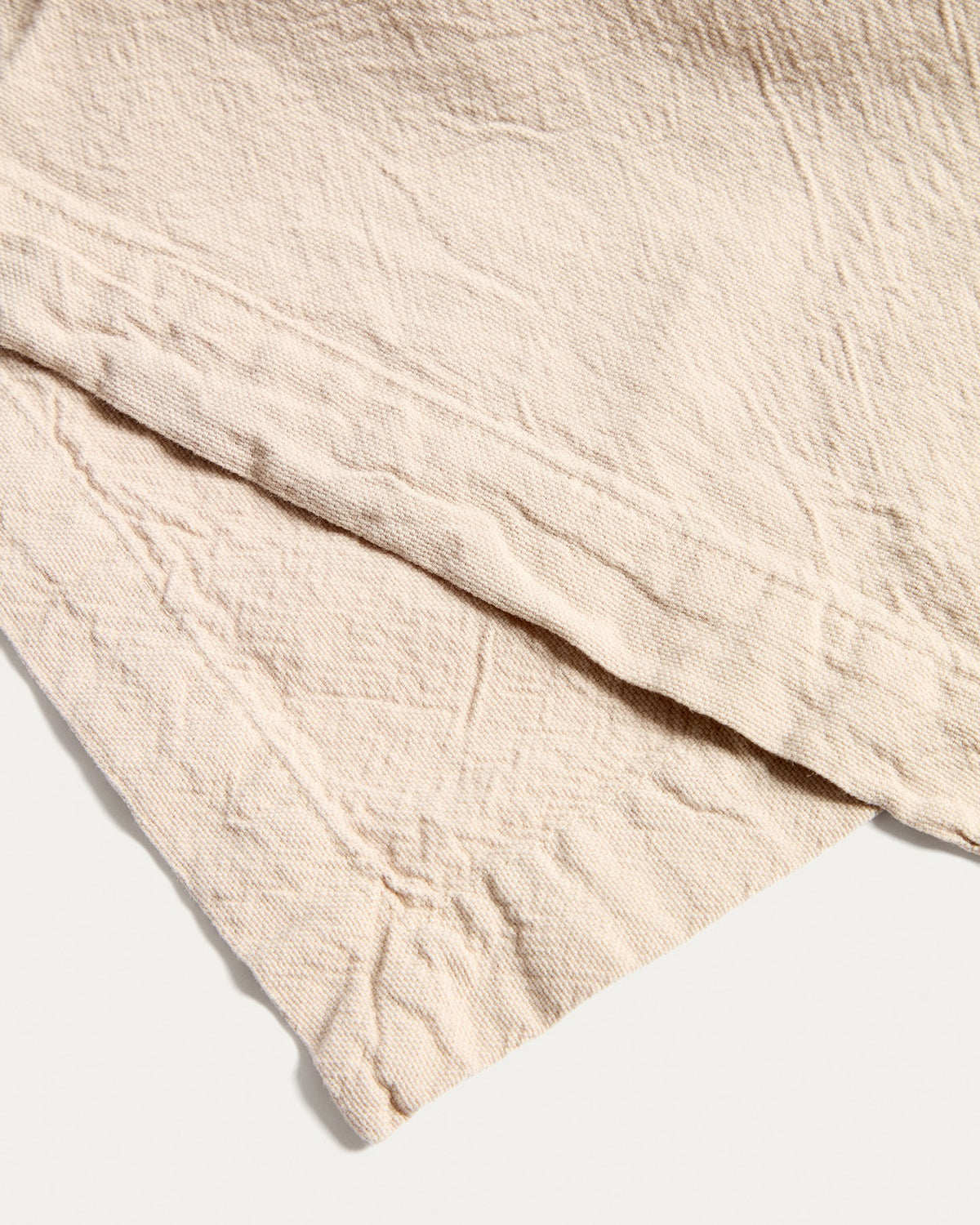 Foto eines steinfarbenen Tischläufers aus Baumwollgewebe mit Washed-Finish, Grösse 50 x 150 cm, auf einem Tisch drapiert.