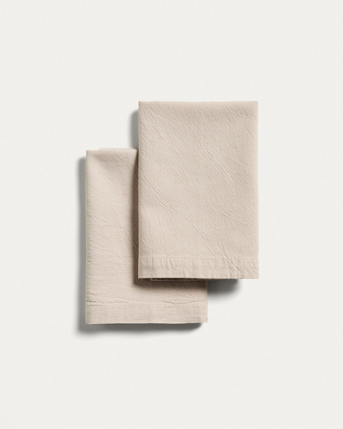 Zwei quadratische Servietten aus Baumwolle mit steingrauem Washed-Finish im Leinen-Look, Grösse 35 x 35 cm, ordentlich gefaltet.