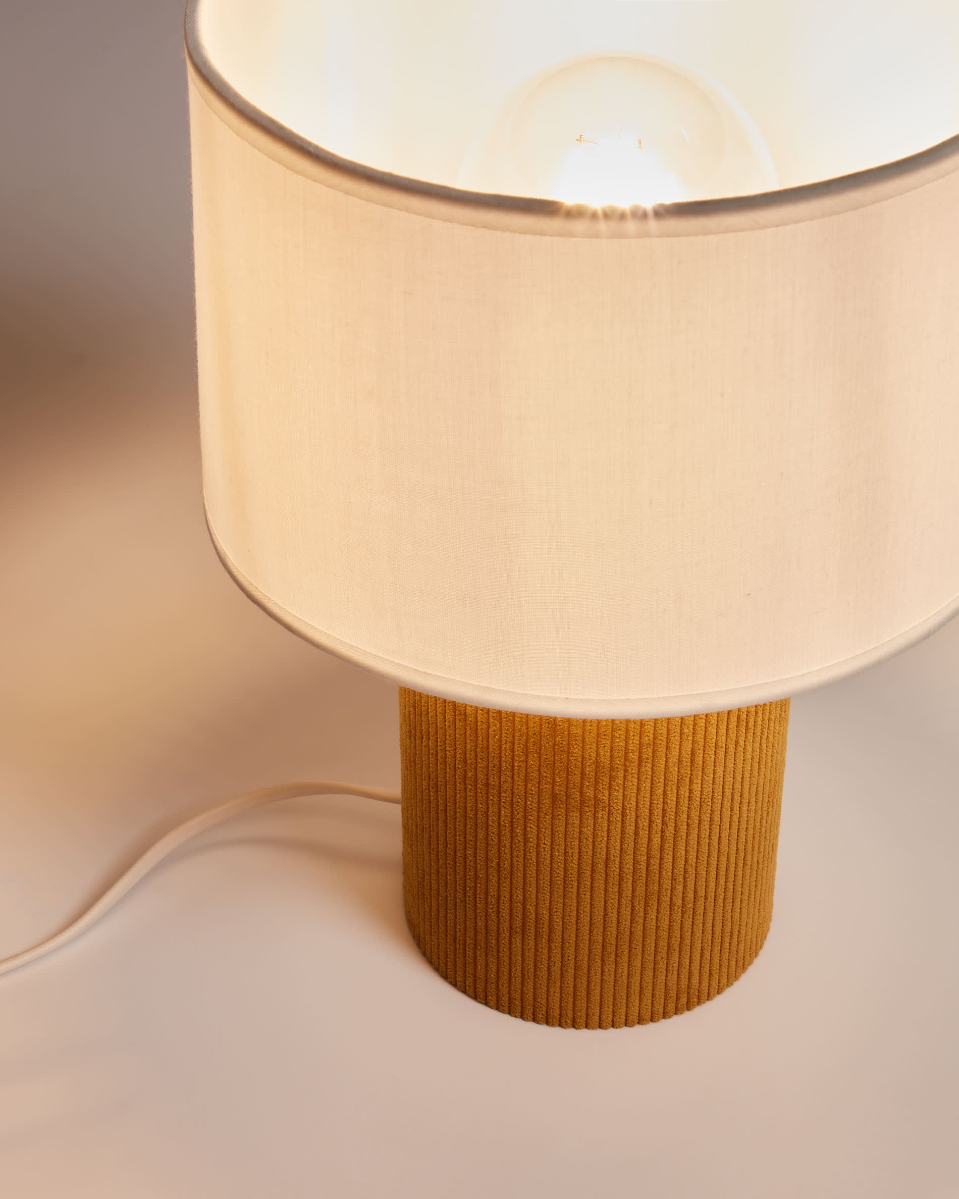 Die stilvolle Tischlampe Bianella in Senfgelb von Kave Home bringt Wärme und Eleganz in jeden Raum und sorgt für eine einladende Atmosphäre.