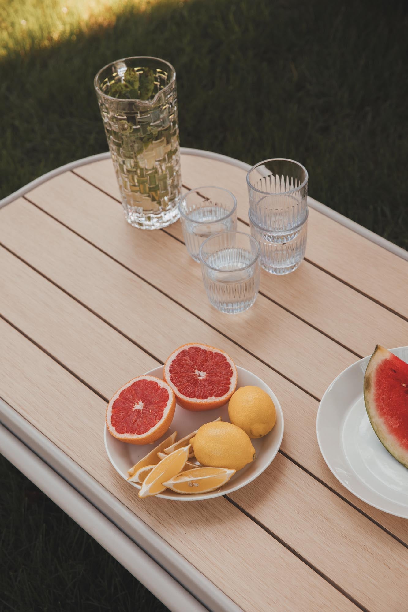 Eleganter Loungetisch aus Aluminium und Holz, ideal für stilvolle Entspannung im Freien.