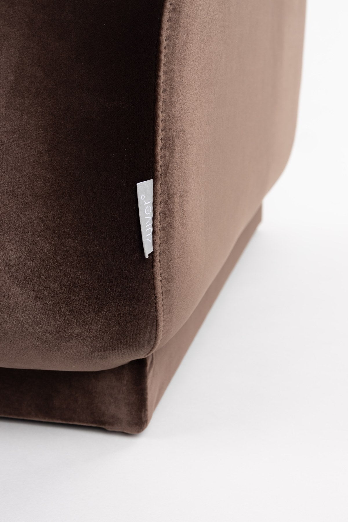 Gepolsterter Hocker Hazel Brown von Zuiver mit runder Form, brauner Polyester-Bezug und Schaumstofffüllung, Masse 127x80x38 cm.