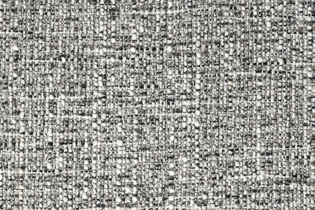 Sessel Brit von Zuiver: gepolsterter Stuhl mit Armlehne in Grau, Sitz aus Polyester, konisch zulaufende schwarze Metallbeine.