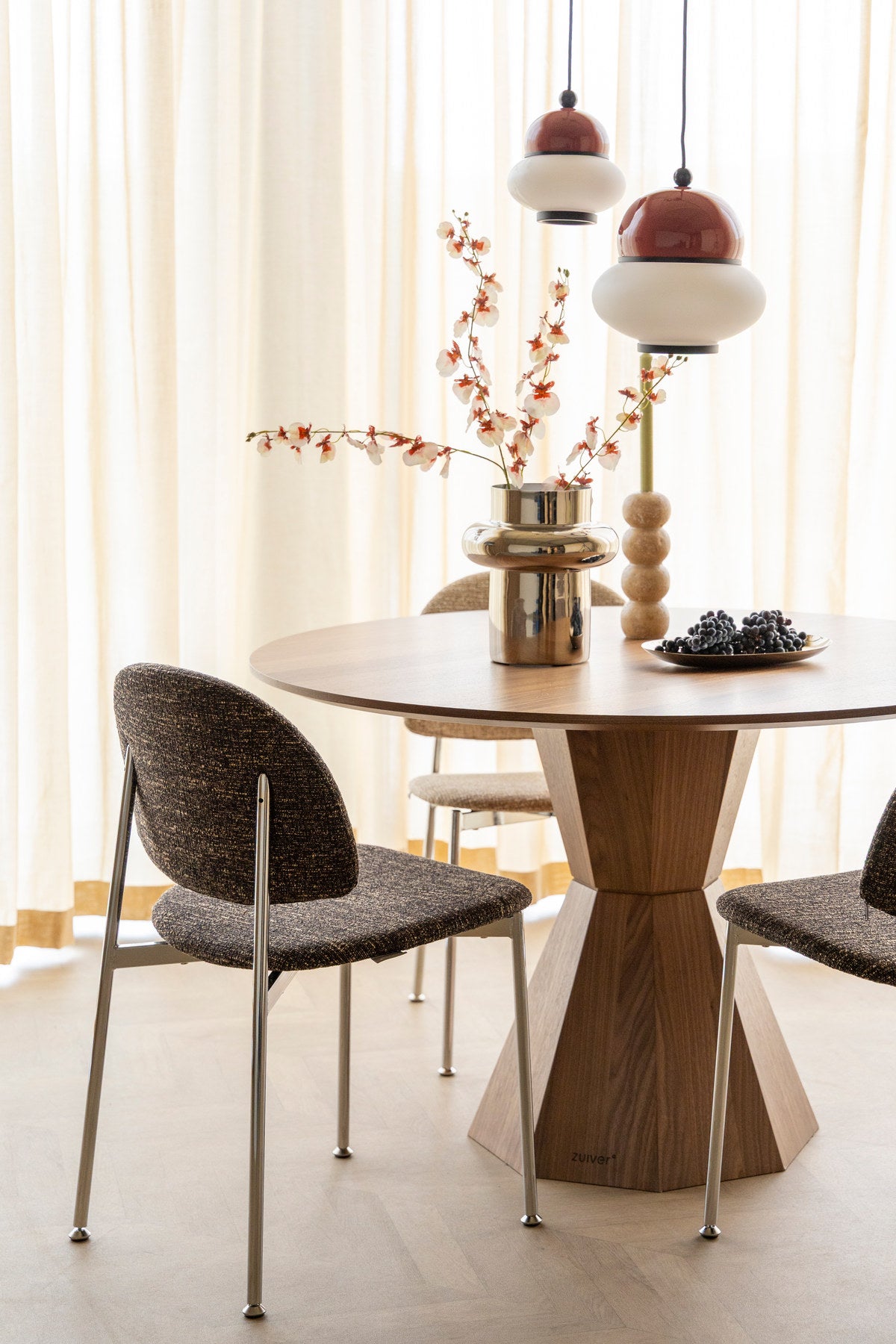 Runder Esstisch Dining Table Lotus Walnut von Zuiver in Braun mit achteckigem, sanduhrförmigem Holzgestell und beschichteter Tischplatte.