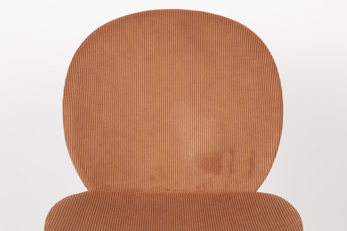 Stuhl Bonnet von Zuiver mit gepolstertem Sitz aus Cordstoff in Oker, schwarzem Metallgestell und schmaler Rückenlehne im Innenbereich.
