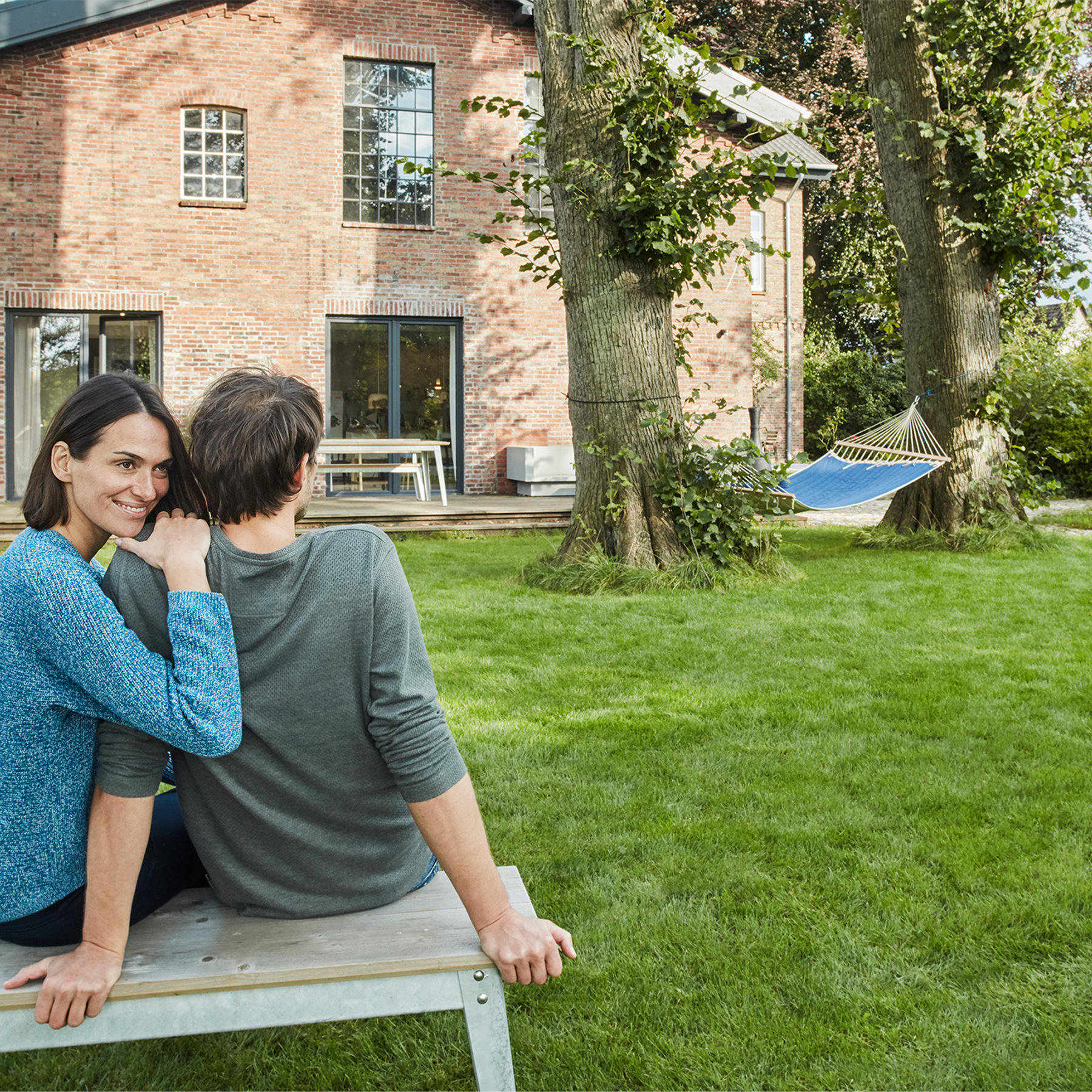 Ehepaar Sitz auf der Bank im grossen Garten vor dem Haus