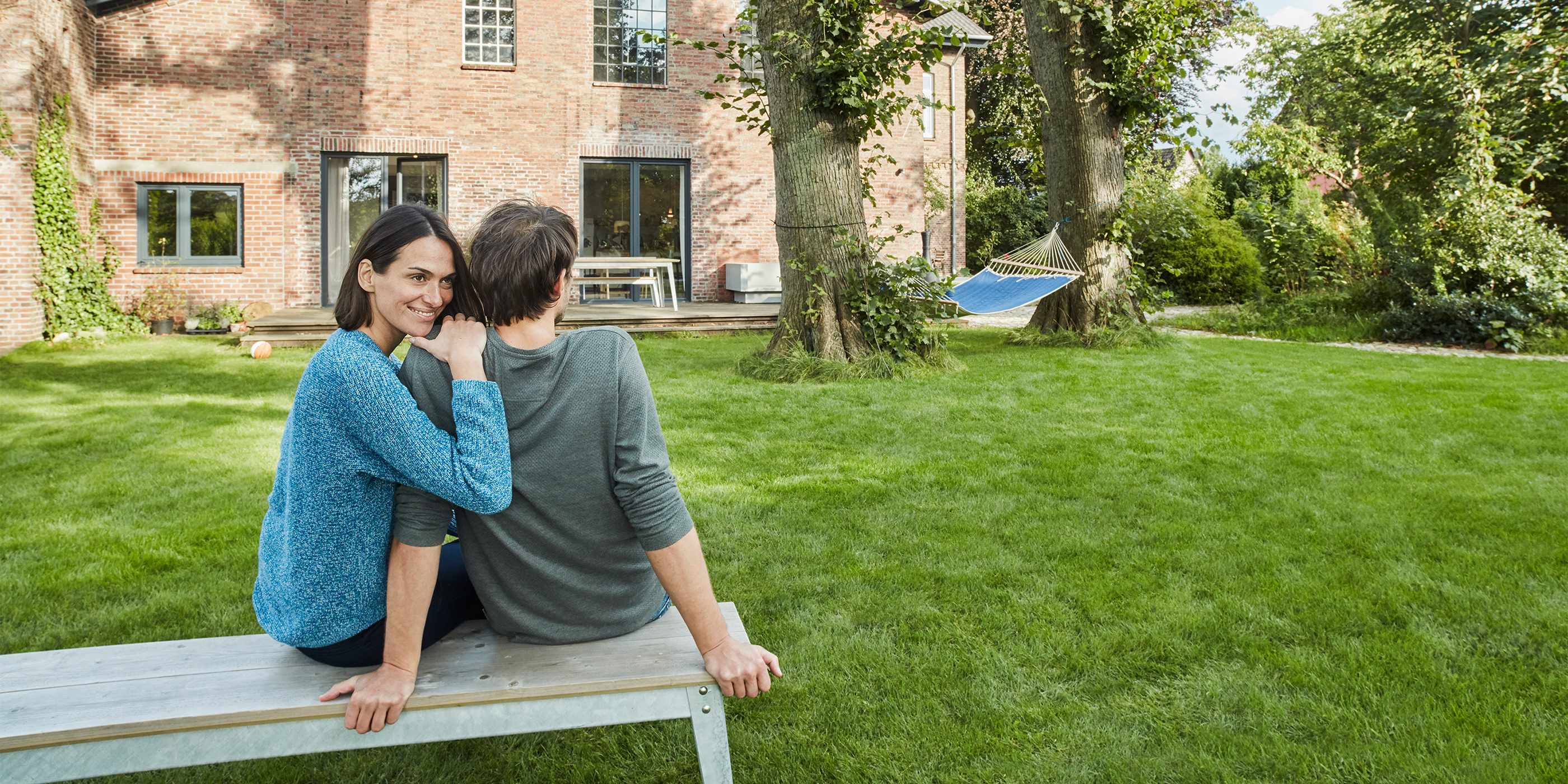 Ehepaar Sitz auf der Bank im grossen Garten vor dem Haus